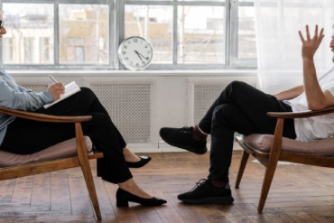 Terapeuta utilizando notebook para marketing digital, otimizando presença online e atraindo pacientes.