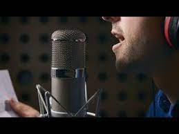 Mulher cantando com microfone, focada e expressiva, demonstrando técnica vocal.