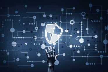 Estudante realizando ethical hacking em um laboratório de computadores com telas exibindo código e diagramas de rede.